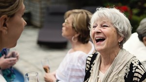 Group of mixed age women chatting at outdoor party