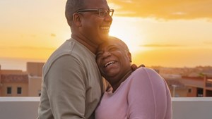 Couple embracing on a rooftop at sunset