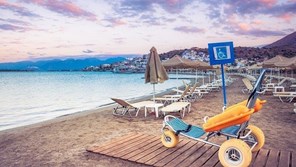 Beach wheelchair on a deck at the edge of the sea