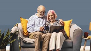 Couple sitting on the couch using a laptop