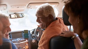 Group of senior friends enjoying road trip in car together