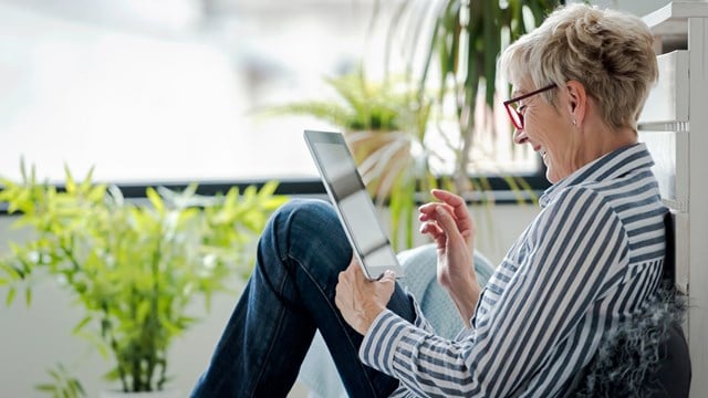 Senior woman using digital tablet at home.