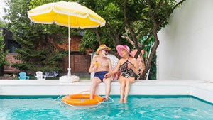 Couple sat by a swimming pool