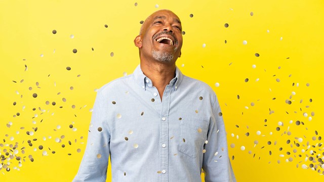 Happy man standing against wall