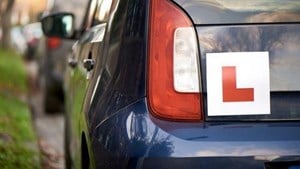 L plate on the back of a blue car