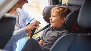 Child being strapped into car seat