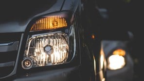 Close up of lit car headlights in the dark