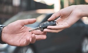 Car keys being handed from one person to another