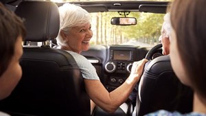 Grandparents and children together in a car on a long journey 