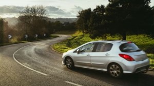 Silver car driving on country road