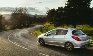 Silver car driving on country road