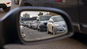 Line of motorway traffic viewed in car wing mirror