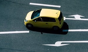 A yellow car turning at a junction.