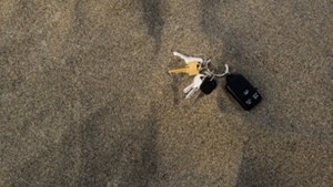 Bunch of keys sitting on dark beach sand