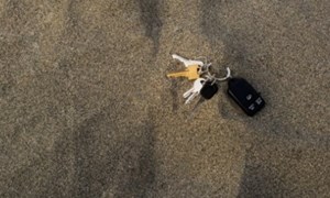 Bunch of keys sitting on dark beach sand