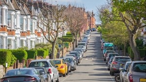 Residential street with cars parked along both sides of the road