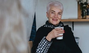 An older woman socialising in winter with friend.