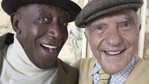 Two elderly male friends smiling together