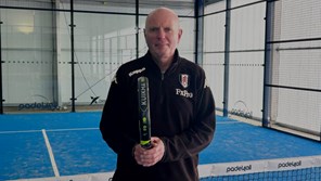 Glenn (63) with padel racket and on the court.