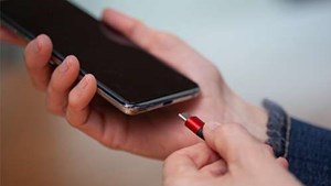 Hands plugging a charger into a mobile