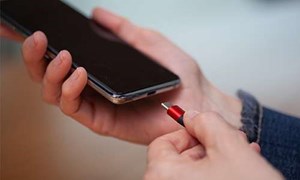 Hands plugging a charger into a mobile