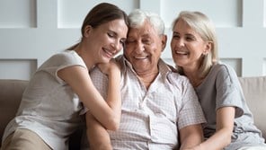 Elderly man with wife and daughter , hugging each other.