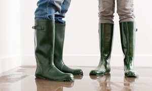 Two people standing on a wet floor wearing wellies