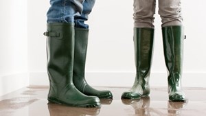 Two people standing on a wet floor wearing wellies