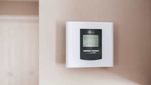 White thermostat hanging on a wall