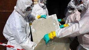 People in hazmat suits disposing of asbestos