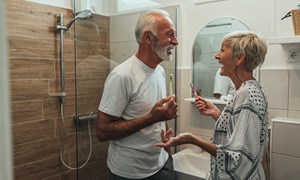 Smiling older couple standing in their bathroom