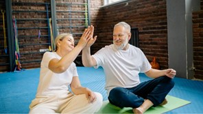 Couple high five after a work out in their home gym.