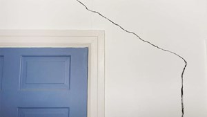 Large crack in a wall beside and over a doorway