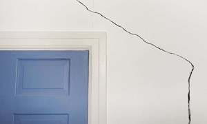 Large crack in a wall beside and over a doorway