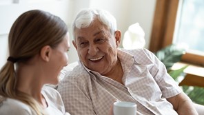 Grandfather and adult granddaughter laughing together