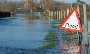 Flooded road with flood warning sign