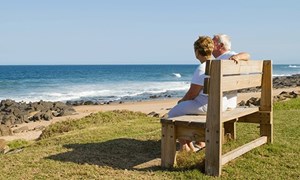 00227 - Couple sitting on a bench looking out over a beach to sea - 5_3